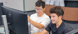 2 males looking at a computer monitor