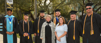 A group of graduating veterans taking a photo with Student Veterans of America advisor Shelly Bearden